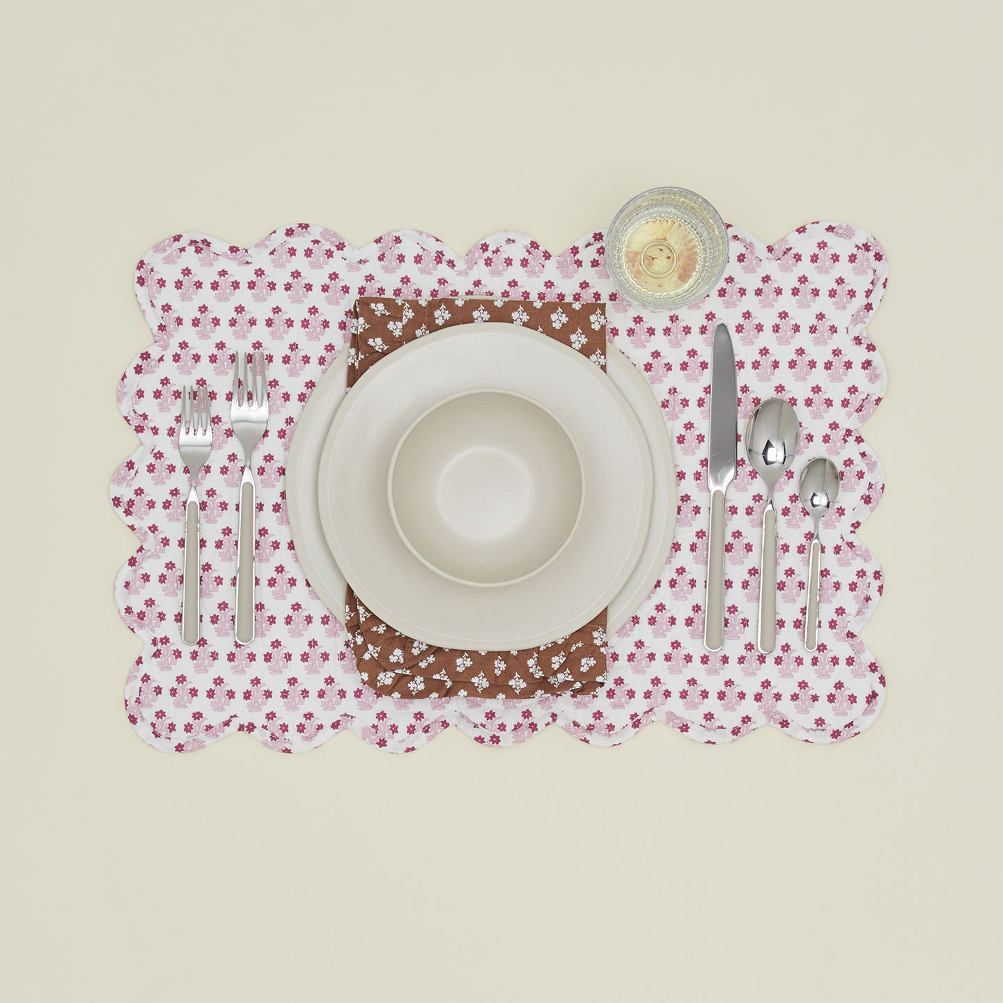 Place setting with a napkin with a ruffled dinner napkin in Constance brown.