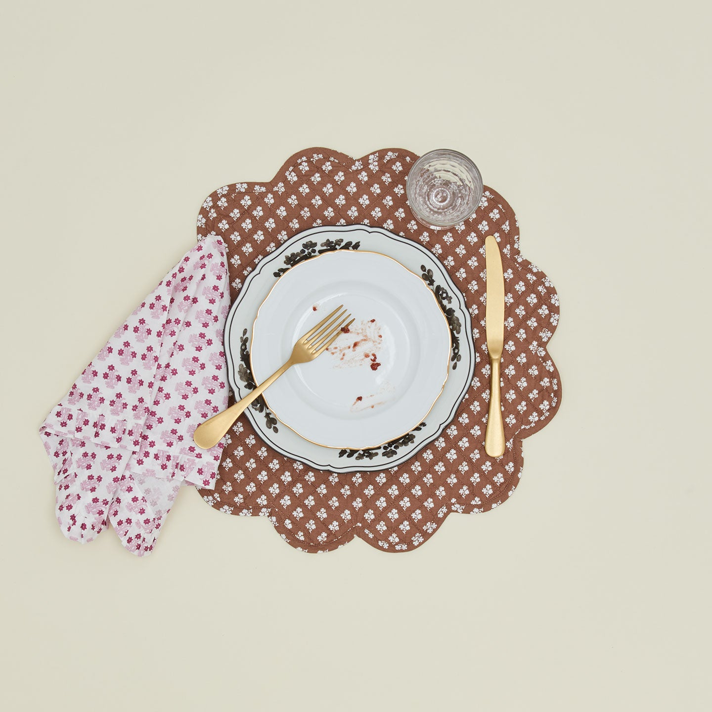 Place setting with a napkin with a ruffled dinner napkin in Abigail pink.