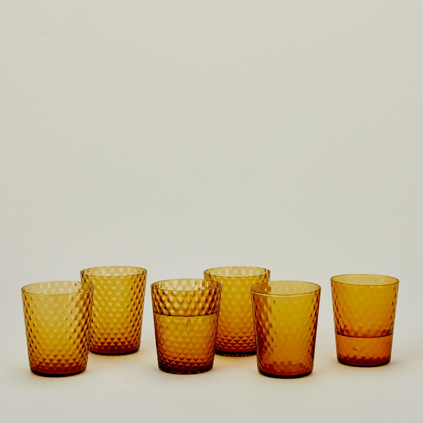 Set of 6 Veneziano Tumblers in Amber, with water.