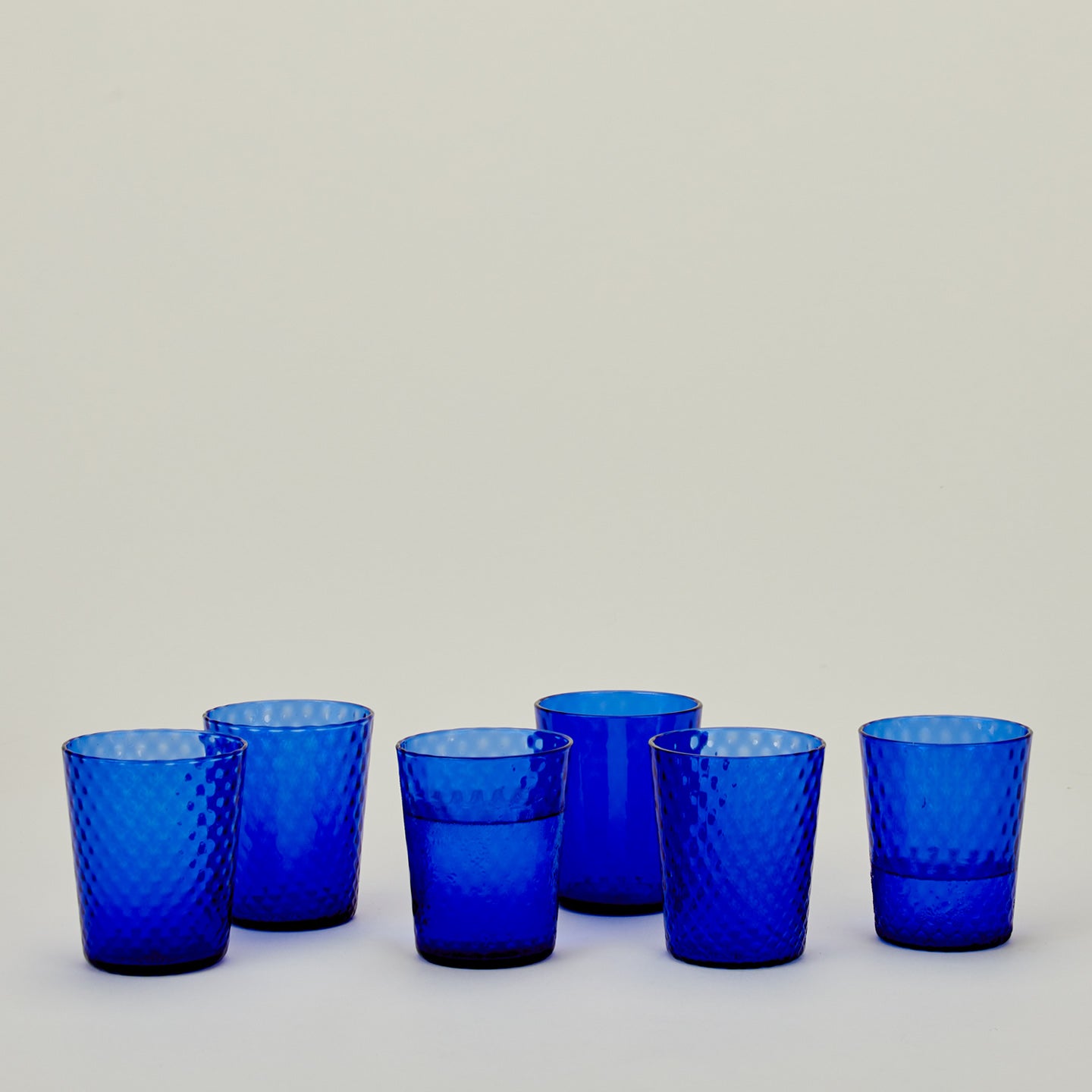 Set of 6 Veneziano Tumblers in Cobalt, with water.