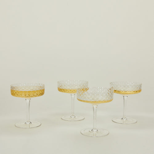 Four Veneziano coupe glasses with champagne.