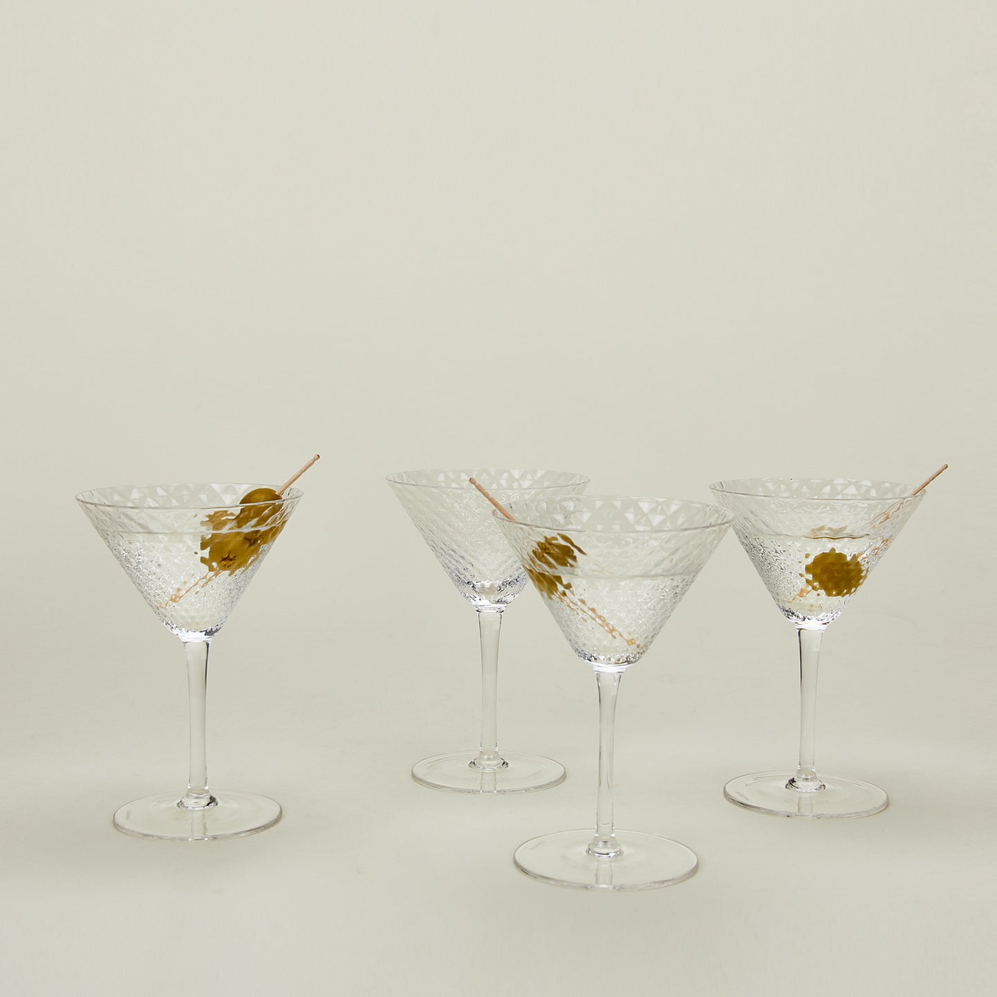 Four Veneziano martini glasses with martinis.